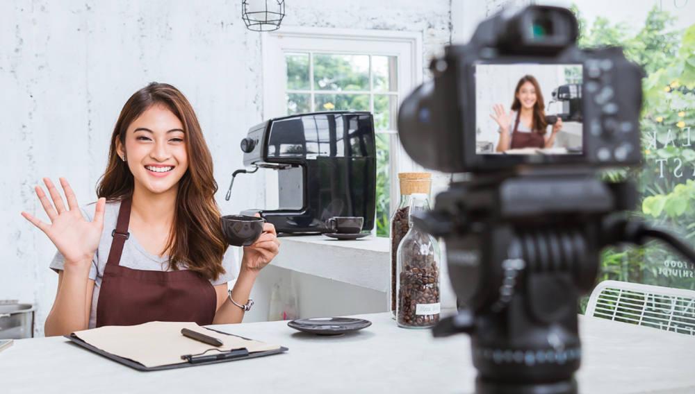 person being filmed, smiling and waving at the camera humanize your brand on social media